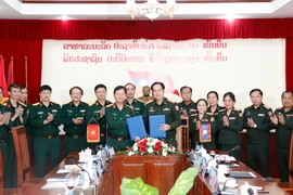 Đại diện Bệnh viện Trung ương 103 QĐND Lào (phải) và đại diện Bệnh viện Quân y 103/Học viện Quân y, QĐND Việt Nam ký Biên bản làm việc. (Ảnh: Phạm Kiên/TTXVN)