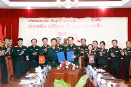 Đại diện Bệnh viện Trung ương 103 QĐND Lào (phải) và đại diện Bệnh viện Quân y 103/Học viện Quân y, QĐND Việt Nam ký Biên bản làm việc. (Ảnh: Phạm Kiên/TTXVN)
