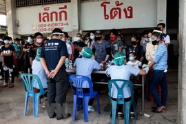 Người dân xếp hàng chờ xét nghiệm COVID-19 tại Samut Sakhon, Thái Lan. (Ảnh: AFP/TTXVN) 