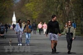 Người dân đi bộ trong một công viên tại London, Anh. (Ảnh: AFP/TTXVN) 
