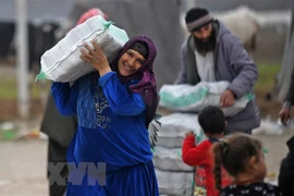 Người tị nạn Syria nhận hàng viện trợ tại trại tị nạn ở thị trấn Mehmediye, Syria. (Ảnh: AFP/TTXVN) 