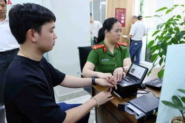 Công dân lấy dấu vân tay khi đến làm thủ tục cấp thẻ căn cước. (Ảnh: Phạm Kiên/TTXVN)