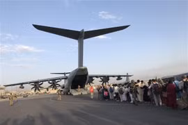 Người dân xếp hàng chờ lên máy bay quân sự để rời Afghanistan tại sân bay Kabul, ngày 24/8/2021. (Ảnh: THX/TTXVN) 