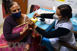 Nhân viên y tế tiêm vaccine phòng COVID-19 cho người dân tại New Delhi, Ấn Độ, ngày 10/1/2022. (Ảnh: THX/TTXVN) 