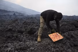 Anh David Garcia nướng pizza trên dung nham từ núi lửa Pacaya ở San Vicente Pacaya, Guatemala ngày 11/5/2021. (Ảnh: AFP/TTXVN)