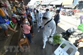 Phun thuốc khử trùng nhằm ngặn chặn sự lây lan của COVID-19 tại một khu chợ ở tỉnh Samut Sakhon, Thái Lan. (Ảnh: THX/TTXVN) 
