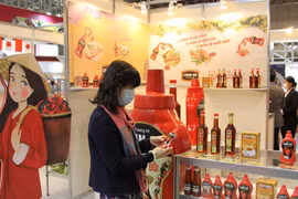 Các đối tác nước ngoài tìm hiểu về nông sản và thực phẩm tại gian hàng quốc gia Việt Nam. (Ảnh: Đào Thanh Tùng/TTXVN)