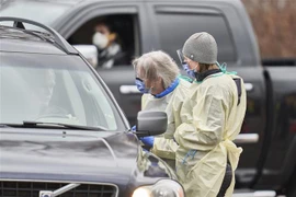 Nhân viên y tế lấy mẫu xét nghiệm COVID-19 cho người dân tại Ontario, Canada ngày 17/3/2020. Ảnh: AFP/TTXVN