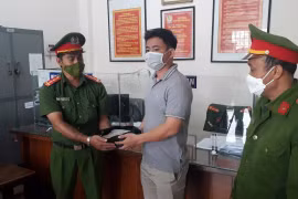 Đại úy Nguyễn Đức Dũng trả lại số tiền cho người bỏ quên. (Ảnh: TTXVN phát)