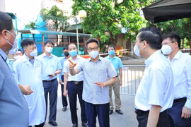 Phó Thủ tướng Chính phủ Vũ Đức Đam, Trưởng Ban chỉ đạo Quốc gia phòng, chống COVID-19 kiểm tra tại khu phong tỏa nhà VP6, bán đảo Linh Đàm. (Ảnh: Minh Đức/TTXVN)
