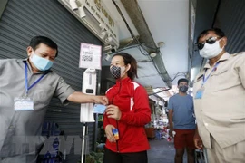 Kiểm tra chứng nhận tiêm phòng COVID-19 của người dân tại một khu chợ ở Malaysia. (Ảnh: THX/TTXVN)