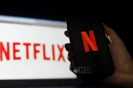Biểu tượng Netflix trên màn hình máy tính và điện thoại di động. (Ảnh: AFP/ TTXVN)