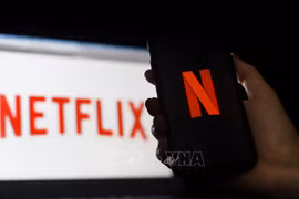 Biểu tượng Netflix trên màn hình máy tính và điện thoại di động. (Ảnh: AFP/ TTXVN)