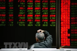 Nhà đầu tư theo dõi bảng chỉ số chứng khoán tại Bắc Kinh, Trung Quốc. (Ảnh: AFP/TTXVN) 