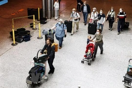 Hành khách đeo khẩu trang phòng lây nhiễm COVID-19 tại sân bay Canada. (Ảnh: AFP/TTXVN) 