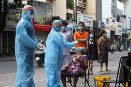 Các nhân viên y tế lấy mẫu xét nghiệm COVID-19 tại TP. Hồ Chí Minh. (Ảnh: Thanh Vũ/TTXVN)