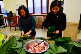 Mọi người cùng nhau gói bánh chưng trong bầu không khí vui vẻ, mang đậm không khí đón Xuân Nhâm Dần. (Ảnh: Mạnh Cường/TTXVN)
