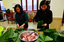 Mọi người cùng nhau gói bánh chưng trong bầu không khí vui vẻ, mang đậm không khí đón Xuân Nhâm Dần. (Ảnh: Mạnh Cường/TTXVN)