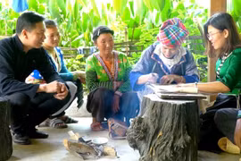 Truyền dạy vẽ sáp ong, một trong những khâu quan trọng của nghề truyền thống dệt vải thổ cẩm ở Lai Châu. (Ảnh: Quý Trung/TTXVN)