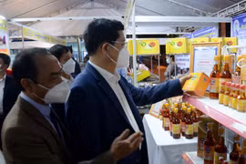 Phó chủ tịch UBND thành phố Đà Nẵng Trần Phước Sơn (bên phải) tham quan các gian hàng sản phẩm nông nghiệp nông thôn tiêu biểu của thành phố Đà Nẵng. (Ảnh: Quốc Dũng/TTXVN)