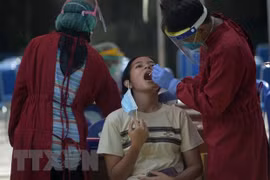 Nhân viên y tế lấy mẫu xét nghiệm COVID-19 tại Jakarta, Indonesia. (Ảnh: THX/TTXVN) 