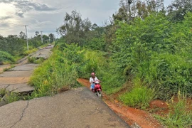 Người dân địa phương vẫn bất chấp nguy hiểm đi qua tuyến đường tránh phía Nam thành phố Bảo Lộc đã bị cấm lưu thông. (Ảnh: Nguyễn Dũng/TTXVN)