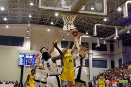 Pha tranh bóng trong trận Nha Trang Dolphins (áo vàng) và Saigon Heat (áo trắng). (Ảnh: Tiến Lực/TTXVN)