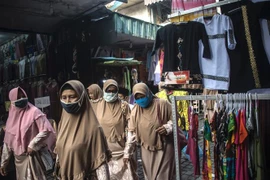 Người dân đeo khẩu trang phòng lây nhiễm COVID-19 tại Surabaya, Indonesia, ngày 17/3/2021. (Ảnh: AFP/TTXVN)