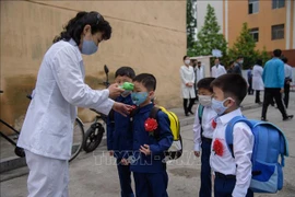 Đo thân nhiệt phòng lây nhiễm COVID-19 tại một trường học ở Bình Nhưỡng. (Nguồn: AFP/TTXVN)