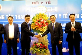 Lãnh đạo Bộ Y tế tặng hoa chúc mừng hội nghị.(Ảnh: Tường Vi - TTXVN)