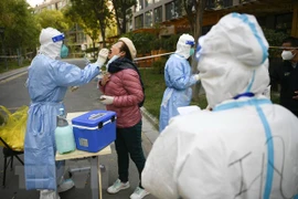 Nhân viên y tế lấy mẫu xét nghiệm COVID-19 cho người dân tại Trung Quốc. (Ảnh: THX/TTXVN) 