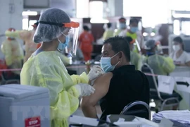 Nhân viên y tế tiêm vaccine phòng COVID-19 cho người dân tại thủ đô Vientiane của Lào (Ảnh: THX/TTXVN)