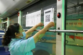 Dán mã QR tại bến xe để hành khách thực hiện khai báo y tế. (Ảnh: Hoàng Hiếu/TTXVN) 