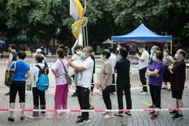 Người dân xếp hàng chờ xét nghiệm COVID-19 tại Quảng Đông, Trung Quốc. (Ảnh: AFP/TTXVN) 