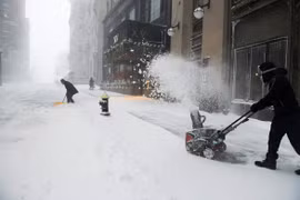 Nhân viên khách sạn XV Beacon dọn tuyết trong trận bão Nor’easter ở TP Boston, bang Massachusetts, Mỹ ngày 29-1.(Ảnh: REUTERS)