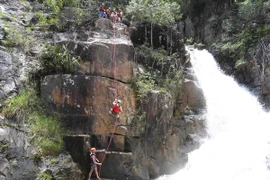 Thành viên trong đoàn kiểm tra trực tiếp trải nghiệm tour du lịch mạo hiểm vượt thác Datanla. (Ảnh: Nguyễn Dũng/TTXVN)
