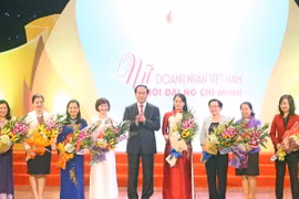 Chủ tịch nước Trần Đại Quang tặng hoa chúc mừng các lãnh đạo nữ khối các bộ, ban ngành Trung ương. (Ảnh: Nhan Sáng/TTXVN)