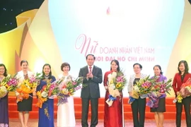 Chủ tịch nước Trần Đại Quang tặng hoa chúc mừng các lãnh đạo nữ khối các bộ, ban ngành Trung ương. (Ảnh: Nhan Sáng/TTXVN)