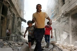 Người dân Syria sơ tán khỏi khu vực đổ nát sau một cuộc không kích ở Aleppo ngày 22/4. (Nguồn: AFP/TTXVN)