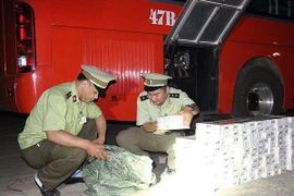 Cán bộ Quản lý thị trường Đắk Lắk kiểm đếm số thuốc lá lậu bị thu giữ. (Ảnh: Phạm Cường/TTXVN)