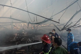Lực lượng chữa cháy đang nỗ lực dập tắt đám cháy. (Ảnh: Dương Chí Tưởng/TTXVN)