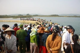 Người dân tập trung đông tại nơi xảy ra vụ đuối nước thương tâm. (Ảnh: Vĩnh Trọng/Vietnam+)