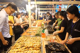 Đông đảo thực khách trong nước và quốc tế thưởng thức món bánh khọt tại liên hoan. (Ảnh: Thanh Vũ/TTXVN)