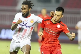 Pha tranh bóng giữa Hữu Tuấn (số 15, Câu lạc bộ Thành phố Hồ Chí Minh) và Henry (9, NamĐịnh). (Ảnh: Quang Nhựt/TTXVN)