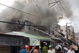 Lực lượng chữa cháy đang tích cực khống chế ngọn lửa. (Ảnh: Trung Hiếu/TTXVN)