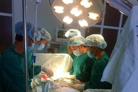 Các bác sỹ thực hiện một ca phẫu thuật cho bệnh nhân. (Ảnh: TTXVN)