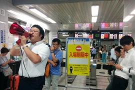 Lực lượng chức năng phong tỏa lối vào nhà ga tàu hỏa sau trận động đất ở Osaka, Nhật Bản. (Ảnh: AFP/TTXVN)