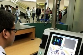 Nhân viên tại Sân bay quốc tế Nội Bài theo dõi thân nhiệt hành khách bằng máy đo tia hồng ngoại. Ảnh minh họa. (Ảnh: Dương Ngọc/TTXVN)