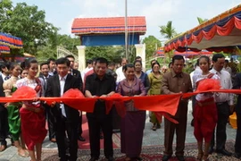 Phó Thủ tướng Men Som Ol và Chủ tịch HĐQT BIDV Trần Bắc Hà cắt băng khánh thành Nhà đa năng. (Ảnh: Trần Chí Hùng/Vietnam+).