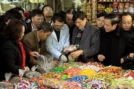 Bộ trưởng Bộ Y tế và Bộ trưởng Bộ Nông nghiệp và Phát triển nông thôn cùng đoàn kiểm tra an toàn thực phẩm tại chợ Đồng Xuân. (Ảnh: Dương Ngọc/TTXVN)